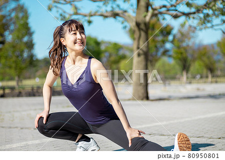公園で準備運動する女性(屈伸) 公園で準備運動する女性(屈伸) 80950801