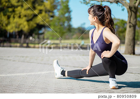 公園で準備運動する女性(屈伸) 公園で準備運動する女性(屈伸) 80950809