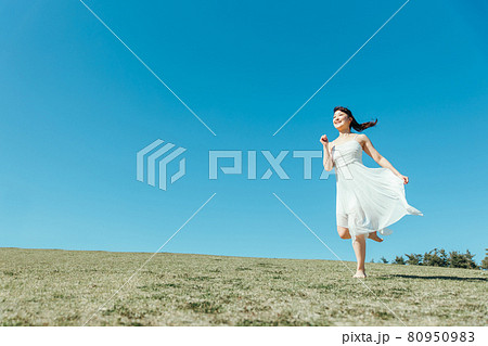 空と白いワンピースの走る女性 80950983