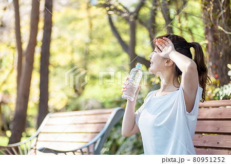 トレーニング中に休憩する女性(水を飲む・笑顔) トレーニング中に休憩する女性(水を飲む・笑顔) 80951252