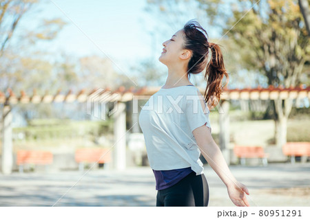 公園でスポーツしながら深呼吸する女性 80951291