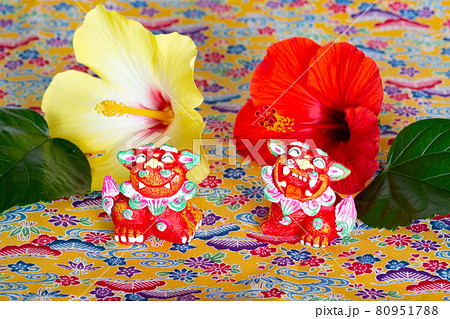 ミンサー織の上に乗るハイビスカスとシーサー 80951788