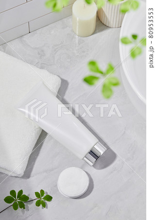 Cosmetics product and cotton towels, cottons pad with green plant on white table inside a bathroom background ceramic. Space for tex Cosmetics product and cotton towels, cottons pad with green plant on white table inside a bathroom background ceramic. Space for tex 80953553