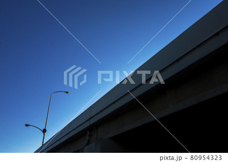 青空背景の高架道路と街灯を仰ぎ見る 80954323