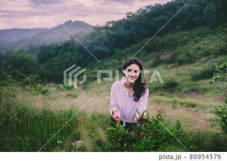 Beautiful woman looking flowers at nature,Happy and smiling,Travel at outdoor 80954576