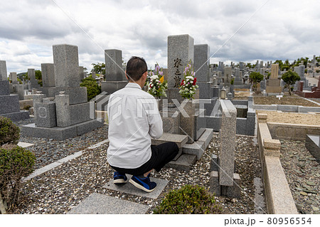 お墓参りをして手を合わせている男性 80956554