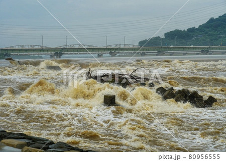 大雨により河川の増水で水が溢れ出る 80956555
