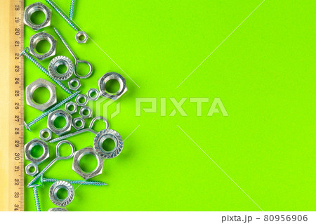 Engineering tools. Bolts and nuts on green background 80956906