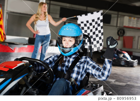 woman driving sport car and woman with race flag on background woman driving sport car and woman with race flag on background 80956953