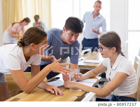 Teenagers working in small groups during lesson at college 80957237