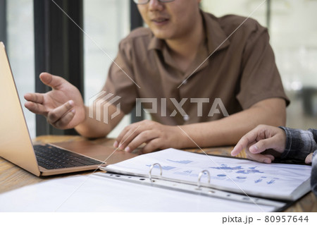 Young businessman explaining some information to his colleague at office desk. Young businessman explaining some information to his colleague at office desk. 80957644