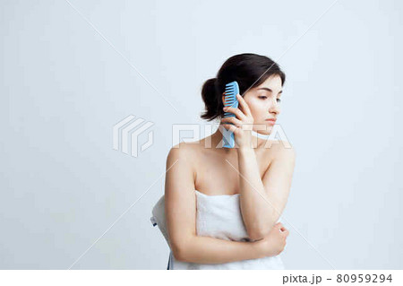 woman with bare shoulders combing hair head care hygiene 80959294