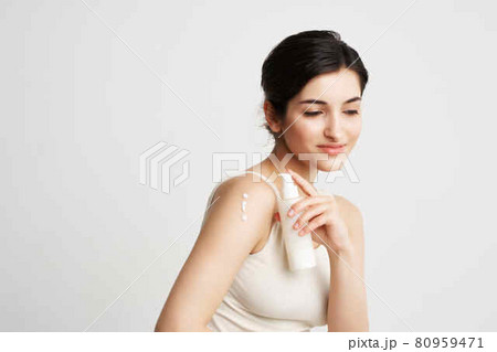 brunette in a white t-shirt with cream in her hands skin rejuvenation care 80959471