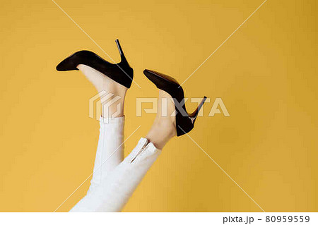 female inverted legs in black shoes cropped view yellow background female inverted legs in black shoes cropped view yellow background 80959559