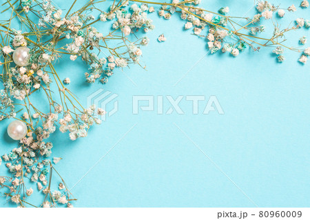 Floral composition with tiny Gypsophila flowers on pastel blue background. Flat lay, top view, copy space 80960009