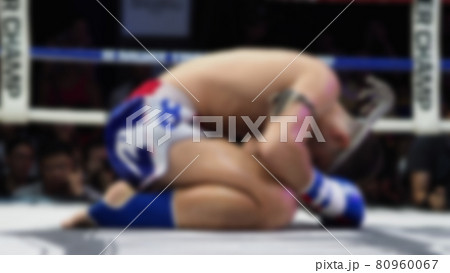 Thai Kick boxing. Blurred images of Muay Thai. Martial Art Kickboxing. Local and foriegn boxer are fighting on the ring at indoor stadium stage. Muaythai is sport competition for traveller sightseeing 80960067