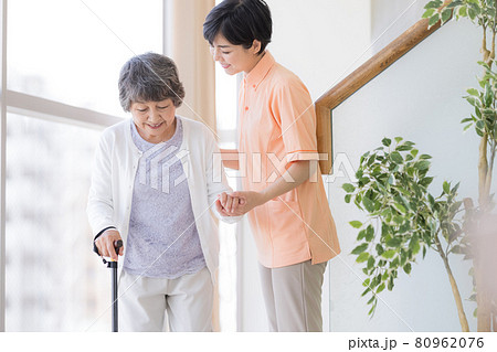 介護イメージ 杖をついて歩くシニア女性と介護士 介護イメージ 杖をついて歩くシニア女性と介護士 80962076