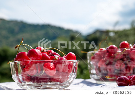 Fresh healthy ripe cherries in glass bowl on table in the garden. Summer sweet seasonal organic fruits. Selective focus 80962259