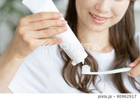 歯ブラシに歯磨き粉をだす若い女性の手元のアップ 80962917