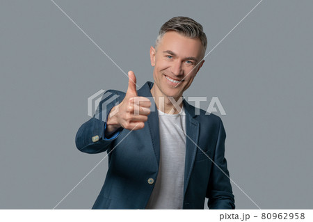 Smiling man in jacket showing ok gesture 80962958
