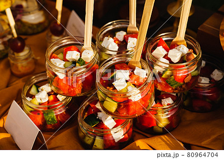 Greek salad in small glass jars at a banquet. catering  80964704