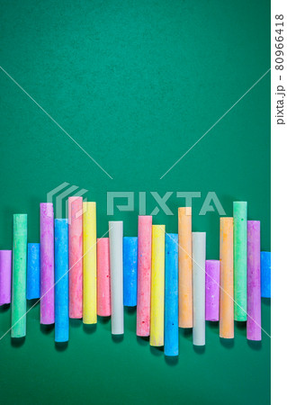 Multicolored chalks on a green chalkboard 80966418