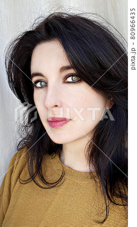 A young woman in a golden colored jumper A young woman in a golden colored jumper 80966435