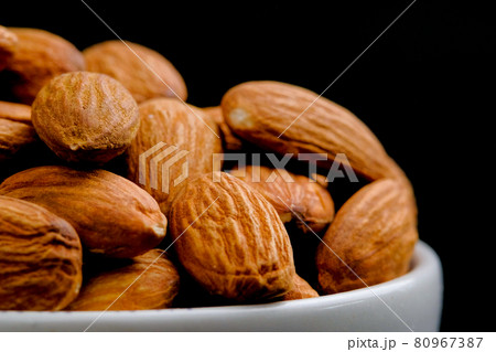 Close up, Almonds nuts in a white bowl on black background. Close up, Almonds nuts in a white bowl on black background. 80967387