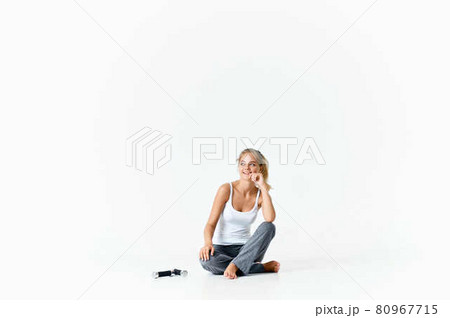 woman sitting barefoot on the floor dumbbells in hands exercise muscles workout 80967715
