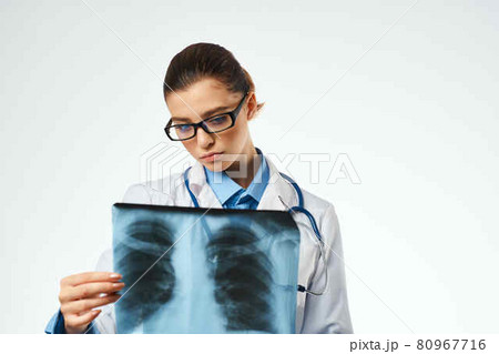 a nurse in a white coat looking at an x-ray Professional examination 80967716