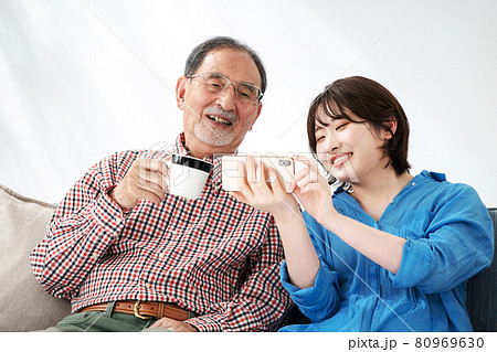 シニア男性　若い女性　家族　孫　おじいちゃん　スマホ 80969630