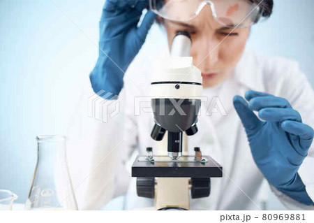 woman in laboratory looking through microscope close-up biotechnology science 80969881