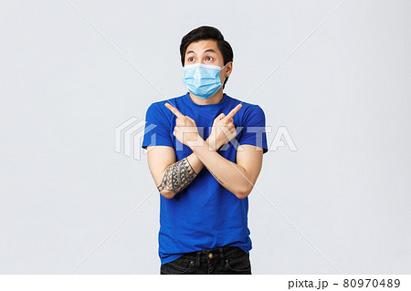 Different emotions, social distancing, quarantine on coronavirus and lifestyle concept. Indecisive and confused asian man in medical mask, pointing left and right, two ways, cant decide few choices Different emotions, social distancing, quarantine on coronavirus and lifestyle concept. Indecisive and confused asian man in medical mask, pointing left and right, two ways, cant decide few choices 80970489