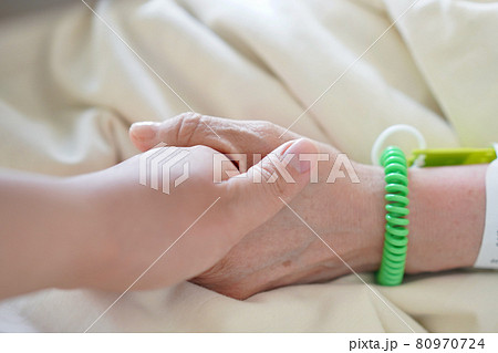 入院する患者と手を握るお見舞いの人 80970724