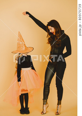 Mother and daughter in haloween costumes pose isolated 80970739
