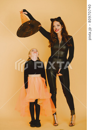 Mother and daughter in haloween costumes pose isolated 80970740