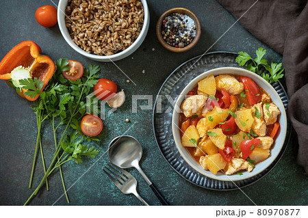 The concept of Diet menu. Homemade turkey or chicken with pineapple sauce and boiled spelled on a dark stone table. Top view flat lay background. 80970877