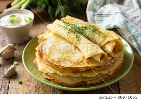 Potato pancakes, not sweet, served with garlic cream sauce on rustic wooden table. Potato pancakes, not sweet, served with garlic cream sauce on rustic wooden table. 80971065