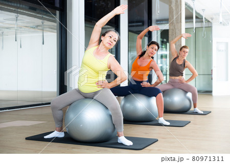 Four women sitting on swiss balls Four women sitting on swiss balls 80971311