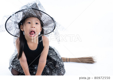 Portrait of little girl in Halloween and carnival costume ride the wooden broom isolated on white background 80972550
