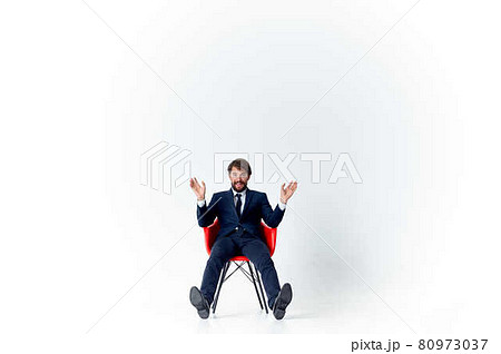 man in suit sitting on red chairs emotions office light background 80973037