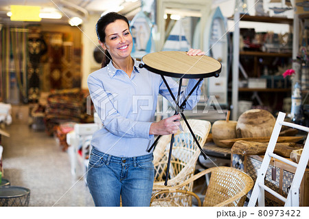 Woman customer choosing wooden stool Woman customer choosing wooden stool 80973422