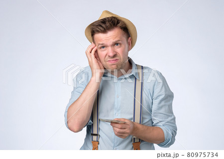 Young businessman holding and counts money dollar bills in hands 80975734