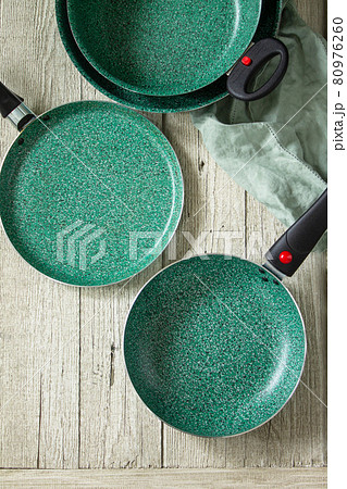 New Set Empty fry pan green with ceramic coatingon on a rustic kitchen table. Top view flat lay background. Copy space. New Set Empty fry pan green with ceramic coatingon on a rustic kitchen table. Top view flat lay background. Copy space. 80976260