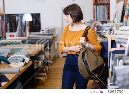 Thoughtful woman in fabric shop 80977304