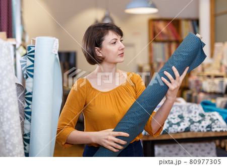 Woman choosing textiles in shop 80977305