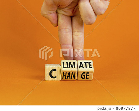 Climate change symbol. Businessman turns cubes with words 'Climate change'. Beautiful orange background. Climate change and ecological concept. Copy space. 80977877
