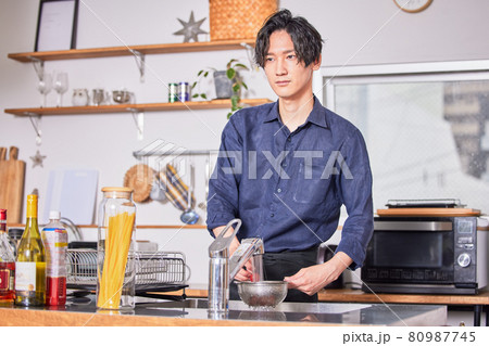 キッチンで料理をするエプロン姿の若い男性　料理男子イメージ 80987745