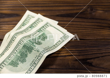 One hundred dollars bills on wooden desk One hundred dollars bills on wooden desk 80988871