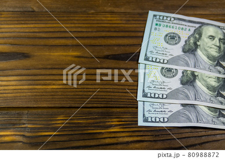 One hundred dollars bills on wooden desk 80988872